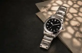 Unbranded steel sports watch beside an archival market ledger in warm geometric light