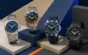 Four unbranded attainable sports watches on a blue and sand geometric editorial set